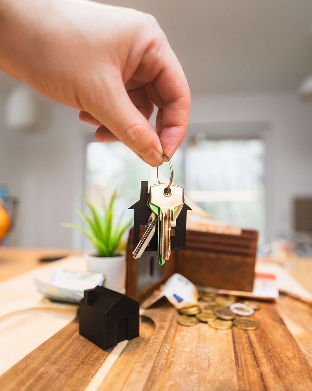 A set of house keys handed over on a kitchen table